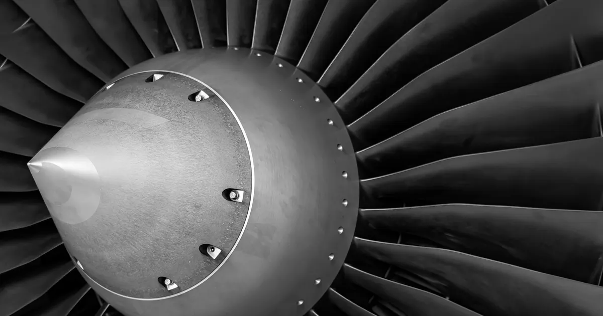 Jet engine fan blades and nose cone in black and white, aerospace hardware context for aerospace prototype machining